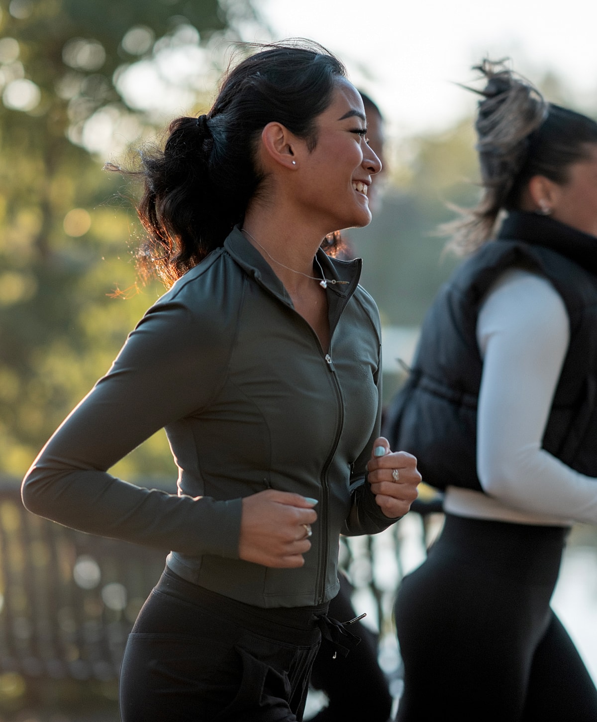 Kalispell body sculpting models jogging outdoors with friends, smiling happily.