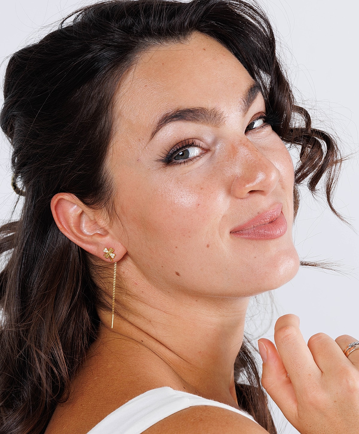 Karispell Botox facial model smiling with flower earrings and wavy hair
