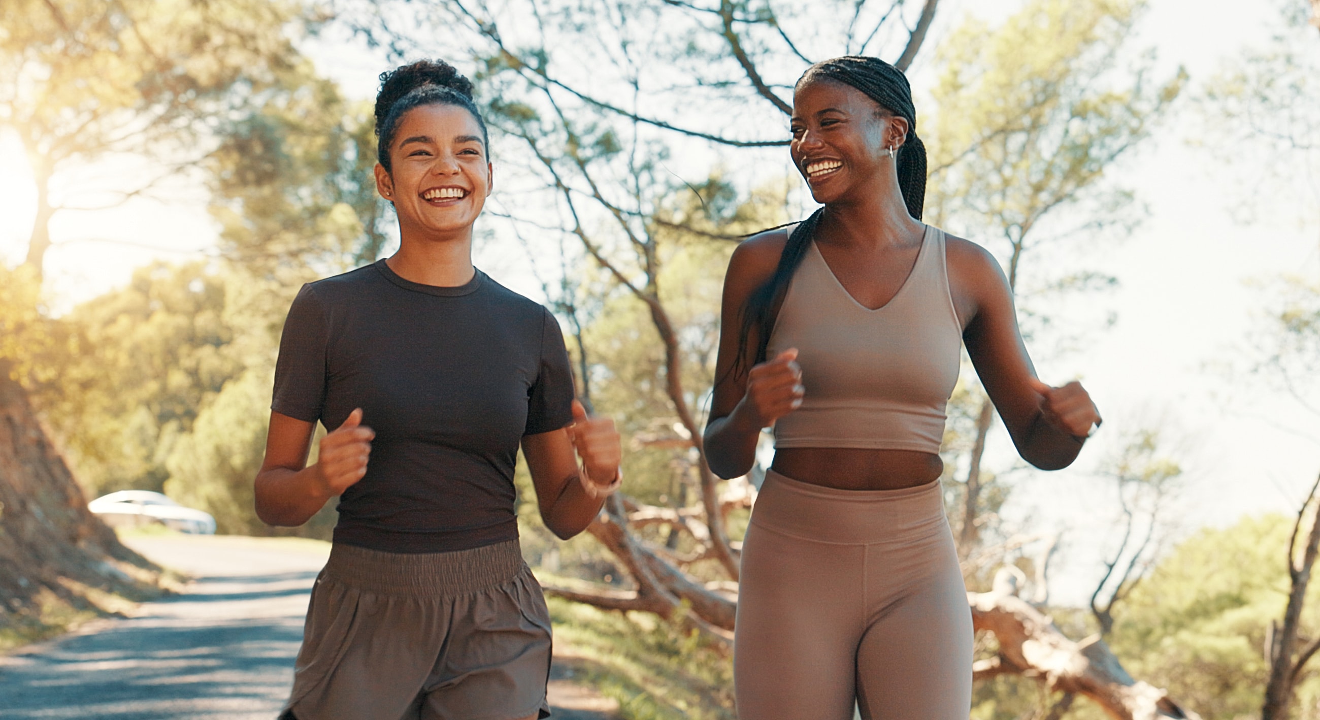 Two Kalispell body sculpting models jogging and laughing outdoors.