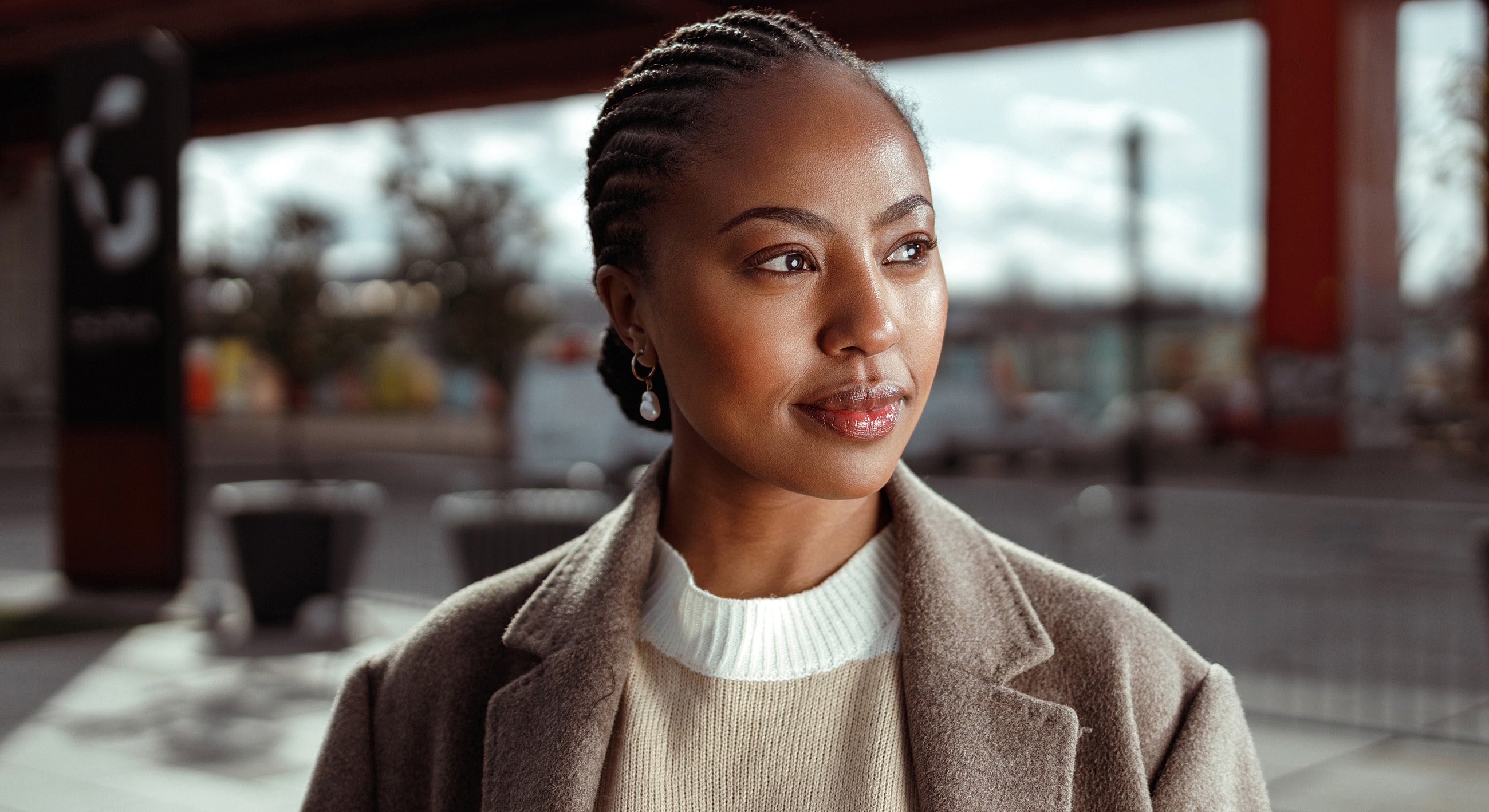 Smiling woman in stylish coat outdoors.